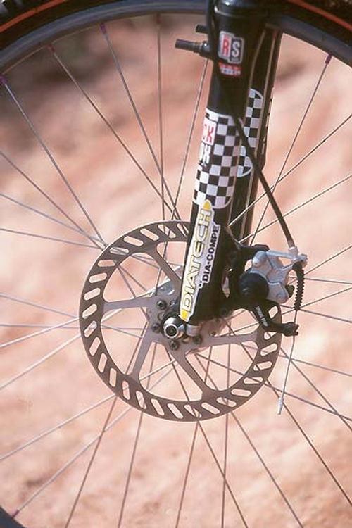 O <i>Dia-Tach Spiral Stop</i> (foto: Bobby Nogueira)” /><br />
O <i>Dia-Tach Spiral Stop</i> (foto: Bobby Nogueira)</div>
<p>Freios a disco vem se tornando cada vez mais populares nas mountain-bikes. É uma tendência forte para o futuro do mountain-bike, atualmente existem diversos e eficientes sistemas de freio a disco. O mais comum são os freios com acionamento hidráulico que por exigirem uma alta tecnologia tornam-se muito caros.</p>
<p>Com o acionamento a cabo é preciso somente do disco / caliper (sistema do freio / burrinho / pastilhas / mola) e do cubo que serve para fixar o disco. Já os manetes de freios podem ser o mesmo utilizado para <i>v-brakes</i>, ou seja a manutenção se torna fácil, o preço fica menor e a reposição de cabos e conduites é fácil.</p>
<p>O <i>Dia-Tach Spiral Stop</i> é um excelente a disco com acionamento a cabo. A <i>Dia-Tech</i> que é uma subdivisão da monstruosa <i>Dia-Compe</i> me forneceu este freio dianteiro direto de Taiwan para testes, após dois meses e quilômetros pedalados, testando no Iron Biker, em aventuras e expedições cheguei a algumas conclusões sobre o freio.</p>
<p>Primeiro o que mais me impressionou e a rapidez do retorno do manete após seu acionamento. O posicionamento do caliper permite que o cabo trabalhe num ângulo em que seu retorno seja rápido a macio.</p>
<p>No caliper existe uma mola que contém três opções de ajuste do manete de freio: acionamento macio, médio e duro. Optei pelo macio que tem impressionado muita gente que o acionou na minha bicicleta pela sua maciez e eficiência no retorno. O trabalho desta mola é ao acionar o manete, ele a tencionara fazendo o burrinho mover-se e pressionar as pastilhas contra o disco. Assim que soltar o acionamento do manete a mola tencionada ira rapidamente retornar a sua forma natural, ou seja, não tencionada retornando o conjunto inteiro rapidamente.</p>
<p>Seu rendimento durante a trilha é bastante satisfatório fazendo com que após alguns acionamentos as pastilhas aqueçam e sua potência duplique, como em carros de corrida onde é preciso um pré-aquecimento de um aquecimento de pneus e freios para ganhar maior aderência. No <i>Dia-Tech</i> quanto mais acionado mais potente ele se torna.</p>
<p>Outra grande diferença dos freios a disco em relação aos <i>v-brakes</i> é que seu sistema de frenagem é baseado onde a física (inércia) age no movimento da roda, ou seja no cubo. Assim ao acionar o disco você ira parar o movimento da roda, e não bloquear o aro como fazem os <i>v-brakes</i>. Tornando o sistema a disco como freios ABS, dificilmente iram travar a roda por completo.</p>
<p>Por incrível que pareça, estes freios são muito mais baratos que os freios hidráulicos, muito mais simples e a com manutenção bem mais fácil. Para conhece-los ao vivo é só me procurar nos maiores eventos de mountain-bike do Brasil que lhe mostrarei e falarei mais sobre o <i>Dia-Tech Spiral Stop</i>. Até a próxima!</p>
<p><strong><em>Este texto foi escrito por: Bobby Nogueira</em></strong></p>
<div class=